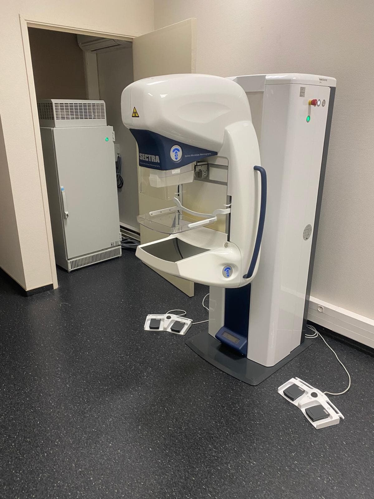 Mammographe Sectra MicroDose en place dans la salle, statif et bras de compression